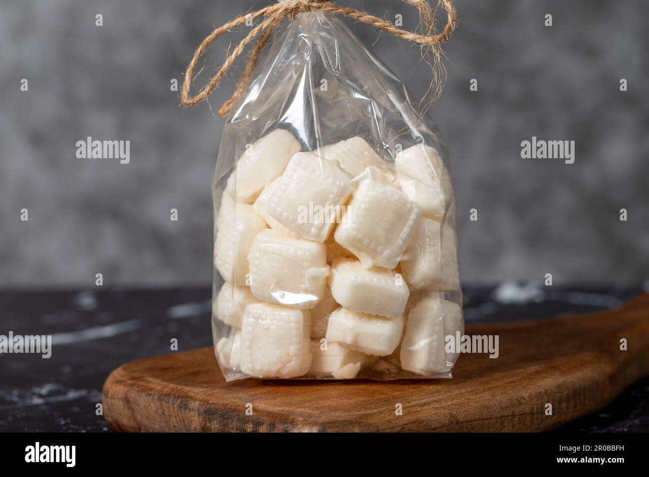 Milk candy. Packed hard milk flavored candy on a dark background. local name mevlana sekeri. Close up Stock Photo