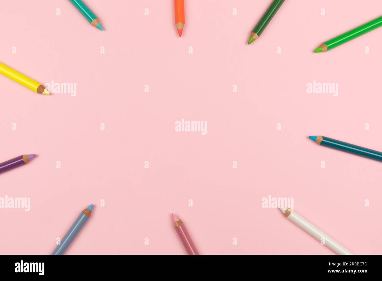 Colored pencils on the pink background. Top view Stock Photo - Alamy