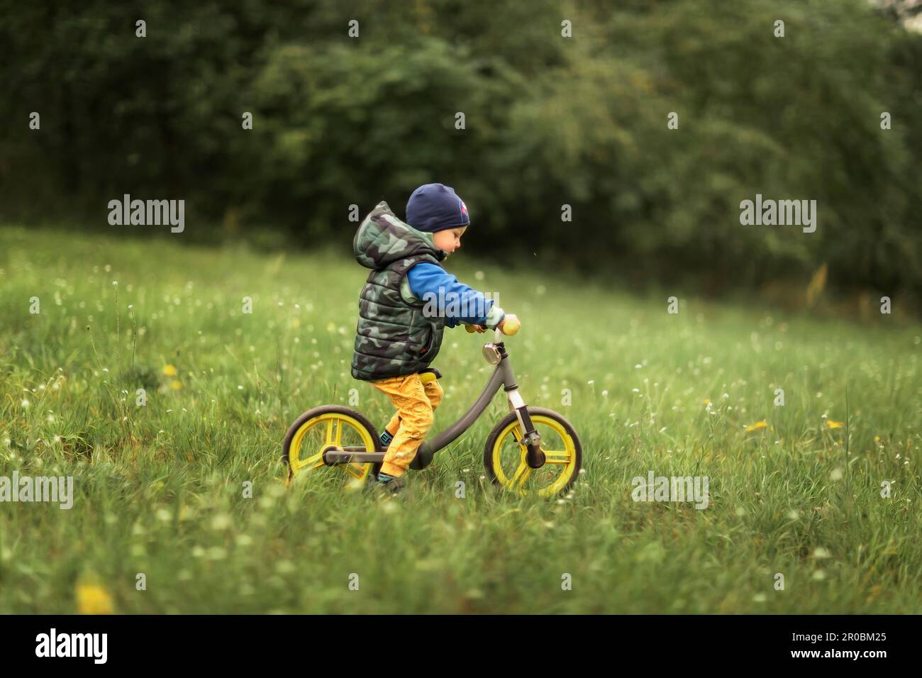 Small boy riding push bike down the hill Stock Photo