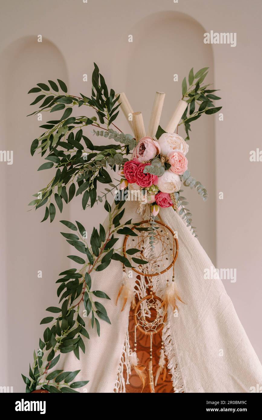 Photozone in the form of a tipi decorated in boho style Stock Photo