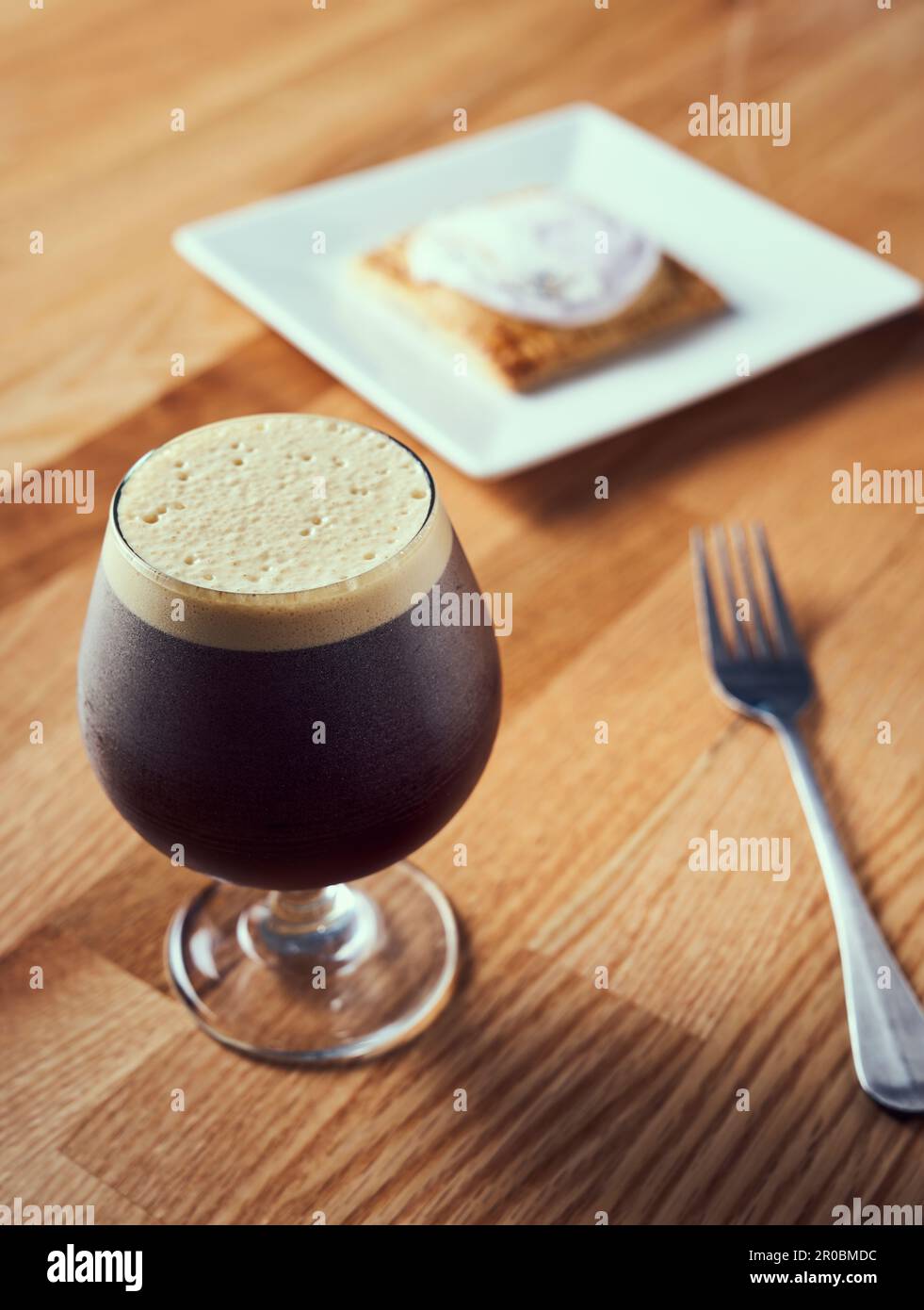 A nitro cold brew served with breakfast pastry. Stock Photo