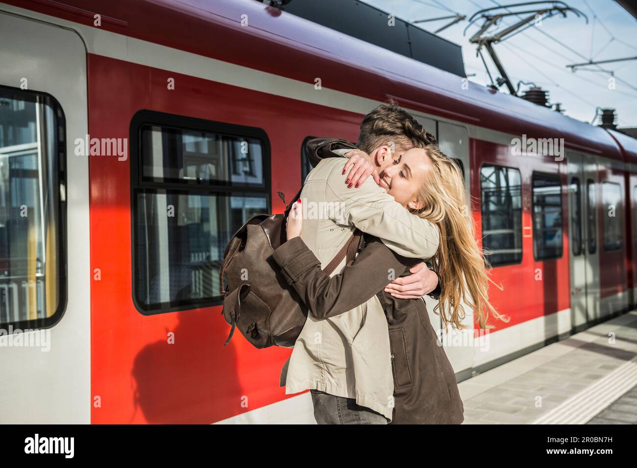 Young Couple Hugging At Train Station Munich Bavaria Germany Stock young-couple-hugging-at-train-station-munich-bavaria-germany-stock