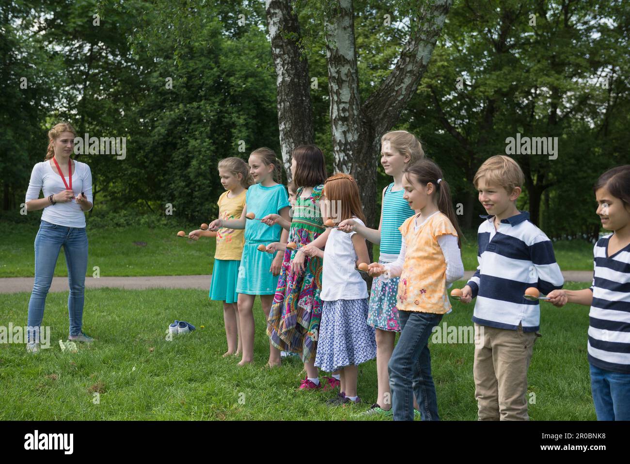 Group of children wait in a row to start the egg race, Munich, Bavaria, Germany Stock Photo