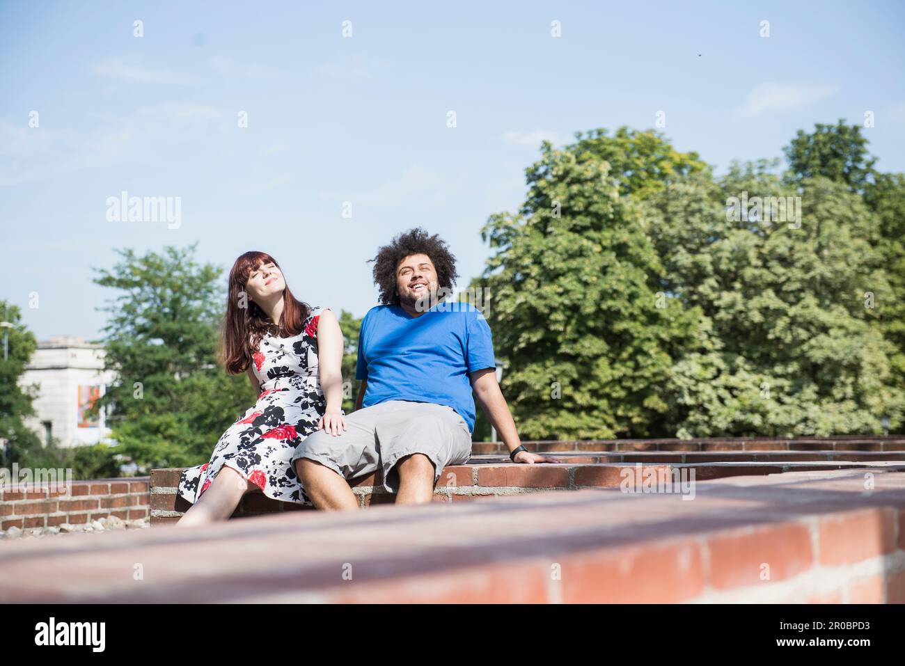 Relaxed young couple sitting outdoors Stock Photo