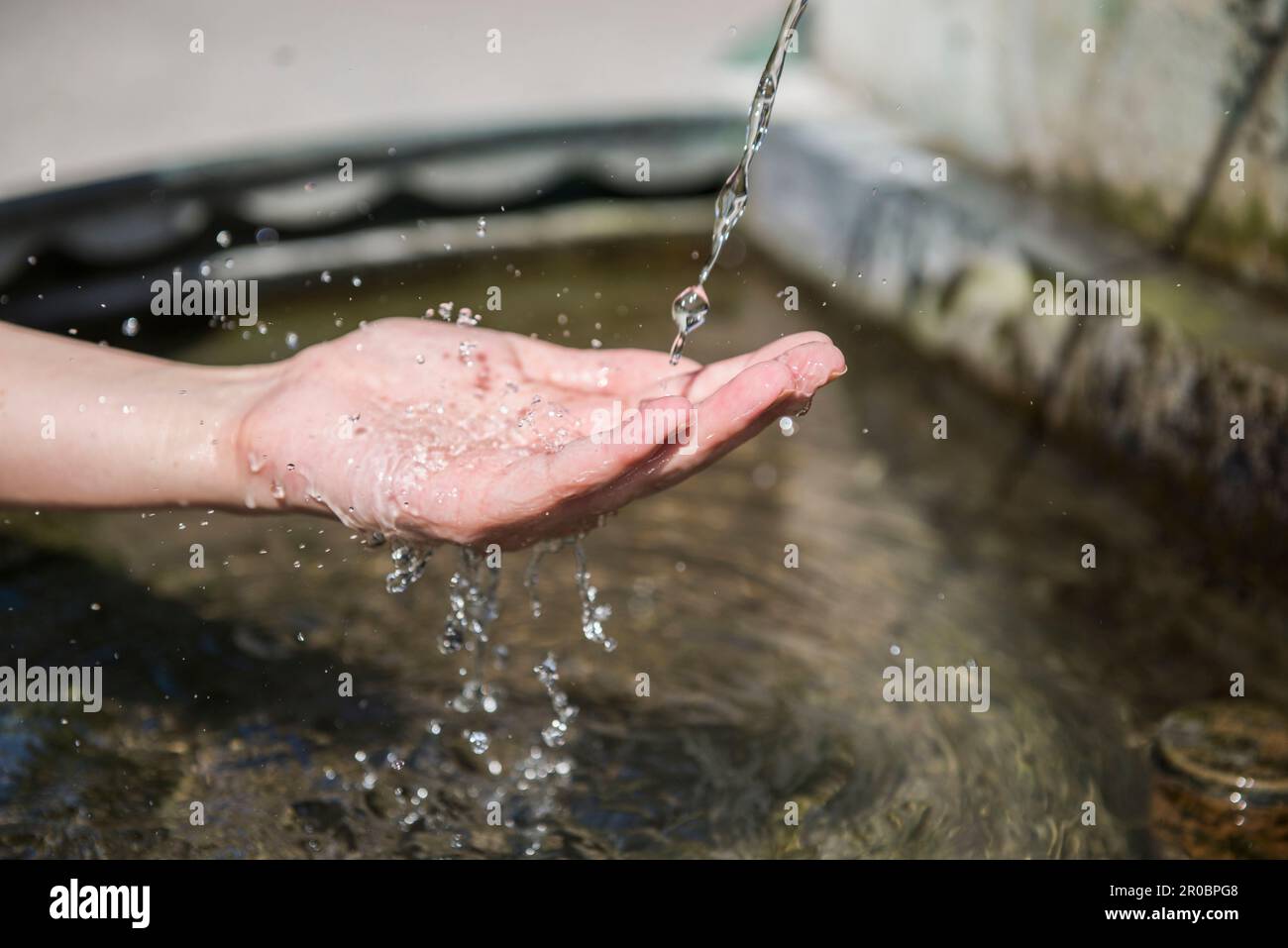 Woman's hand under a fountain Stock Photo