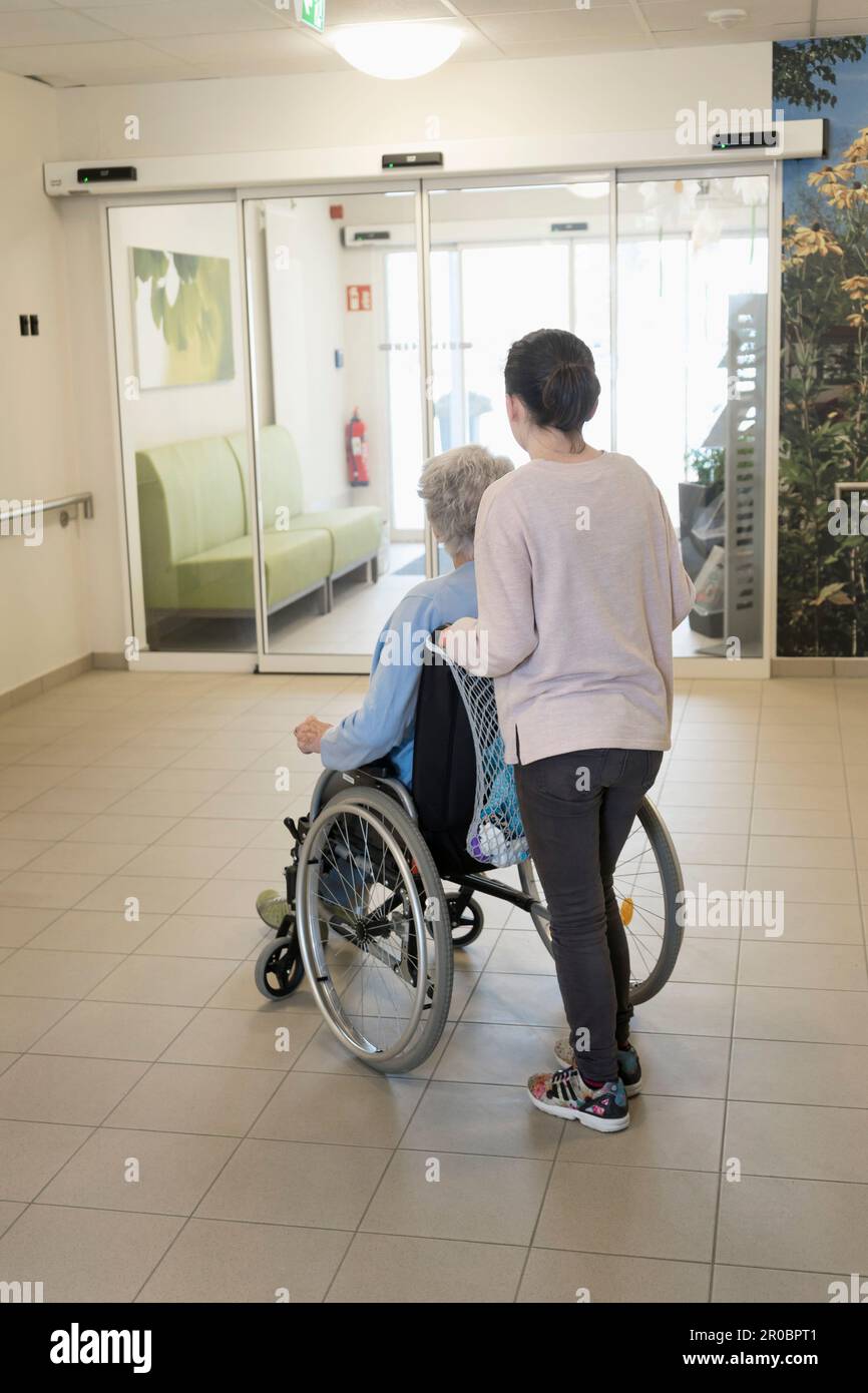 Senior woman in wheelchair with girl in rest home Stock Photo