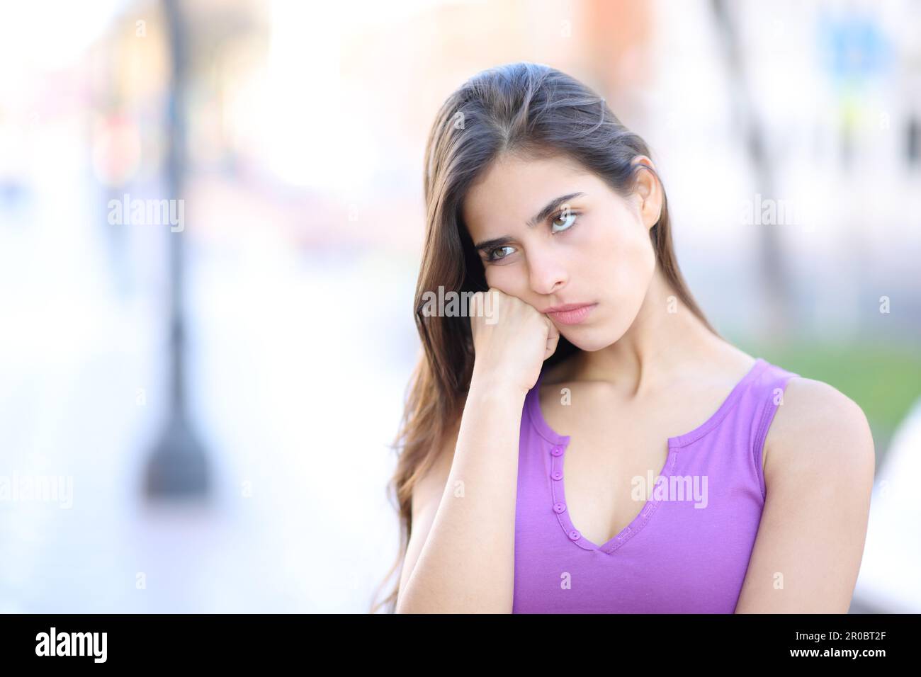 Bored woman looking at side standing in the street Stock Photo
