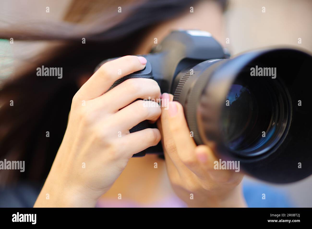 Close up of a photographer taking photos with reflex camera outdoors Stock Photo