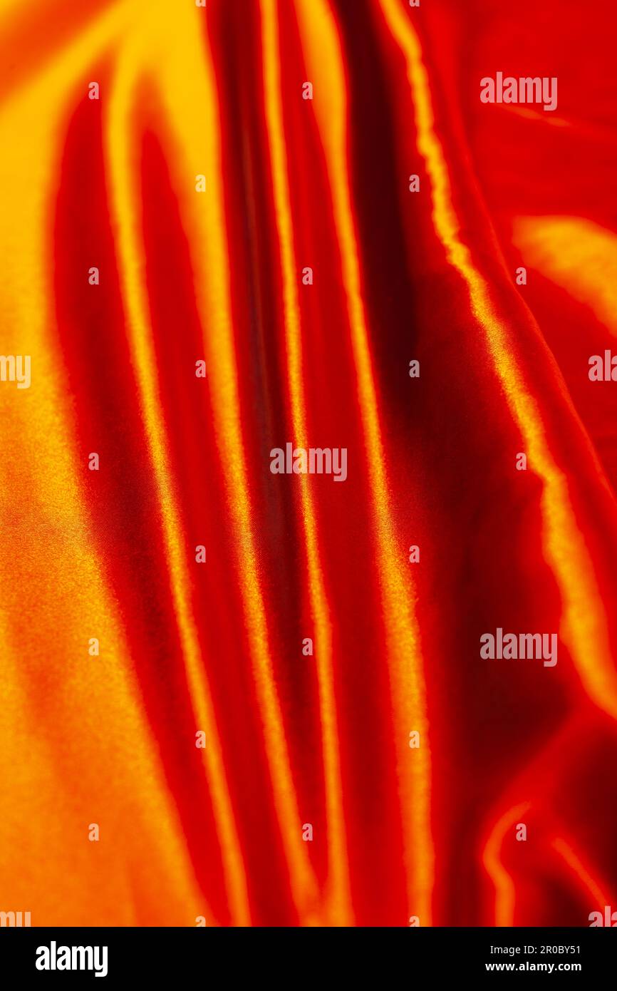 A red satin fabric with several strap wrinkles in the same direction Stock Photo
