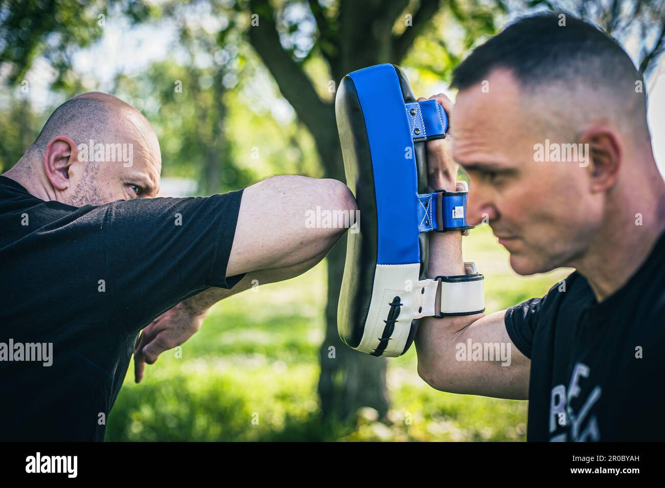 Muay thai trainer holds focus mitts. Elbow kick technique training and
