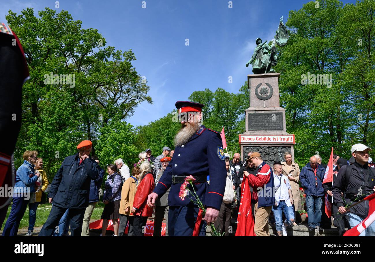 Dresden, Germany. 08th May, 2023. 08 May 2023, Saxony, Dresden: A participant in Cossack uniform takes part in a commemoration of Liberation Day at the Red Army Memorial with the inscription 'This structure is fragile'. The occasion for the Temporary Art Installation at the Soviet Memorial at Olbrichtplatz in Dresden's Albertstadt in cooperation with the Kunsthaus Dresden and the artist Svea Duwe is here not only the liberation from National Socialism and the upcoming renovation of the memorial, but also the historical classification of the memorial required by the Russian war of aggression on Stock Photo