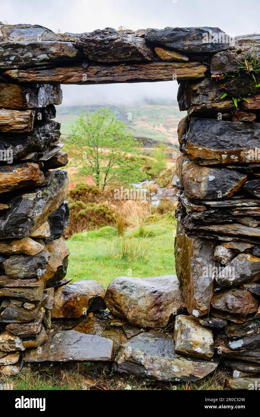 View through a window in remains of Cwm Ciprwth Copper Mine building above Cwm Pennant in Snowdonia National Park. Llanfihangel, Gwynedd, Wales, UK Stock Photo