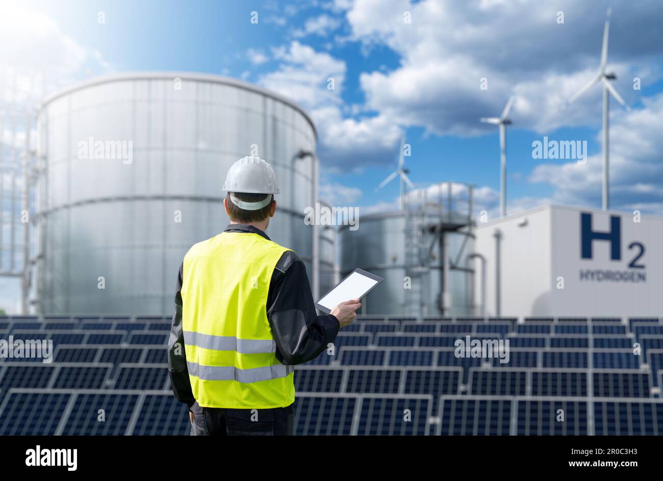 Engineer with tablet computer on a background of Green Hydrogen factory. High quality photo Stock Photo