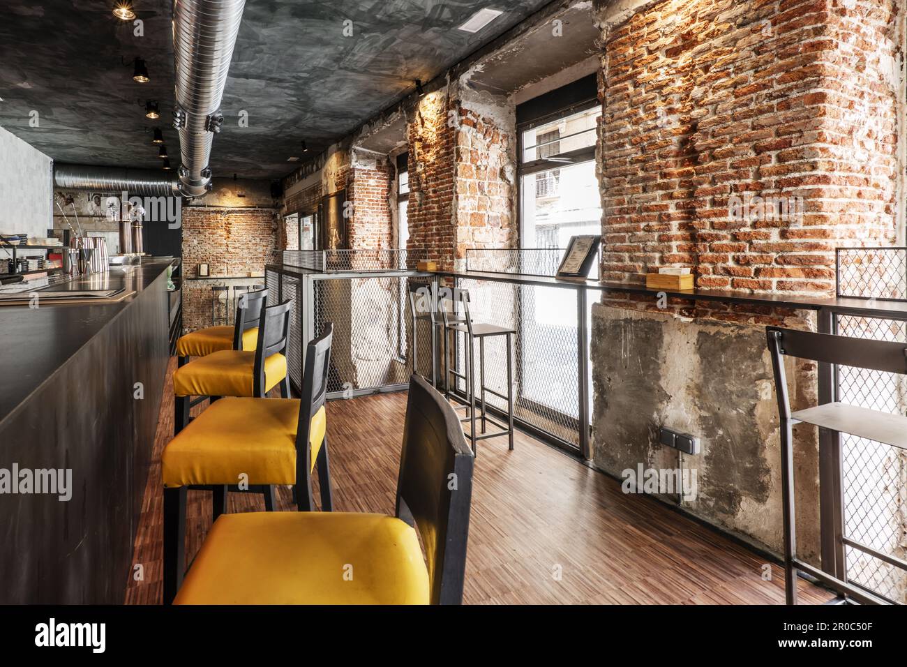 A local bar counter with high armchairs with yellow seats, industrial ...