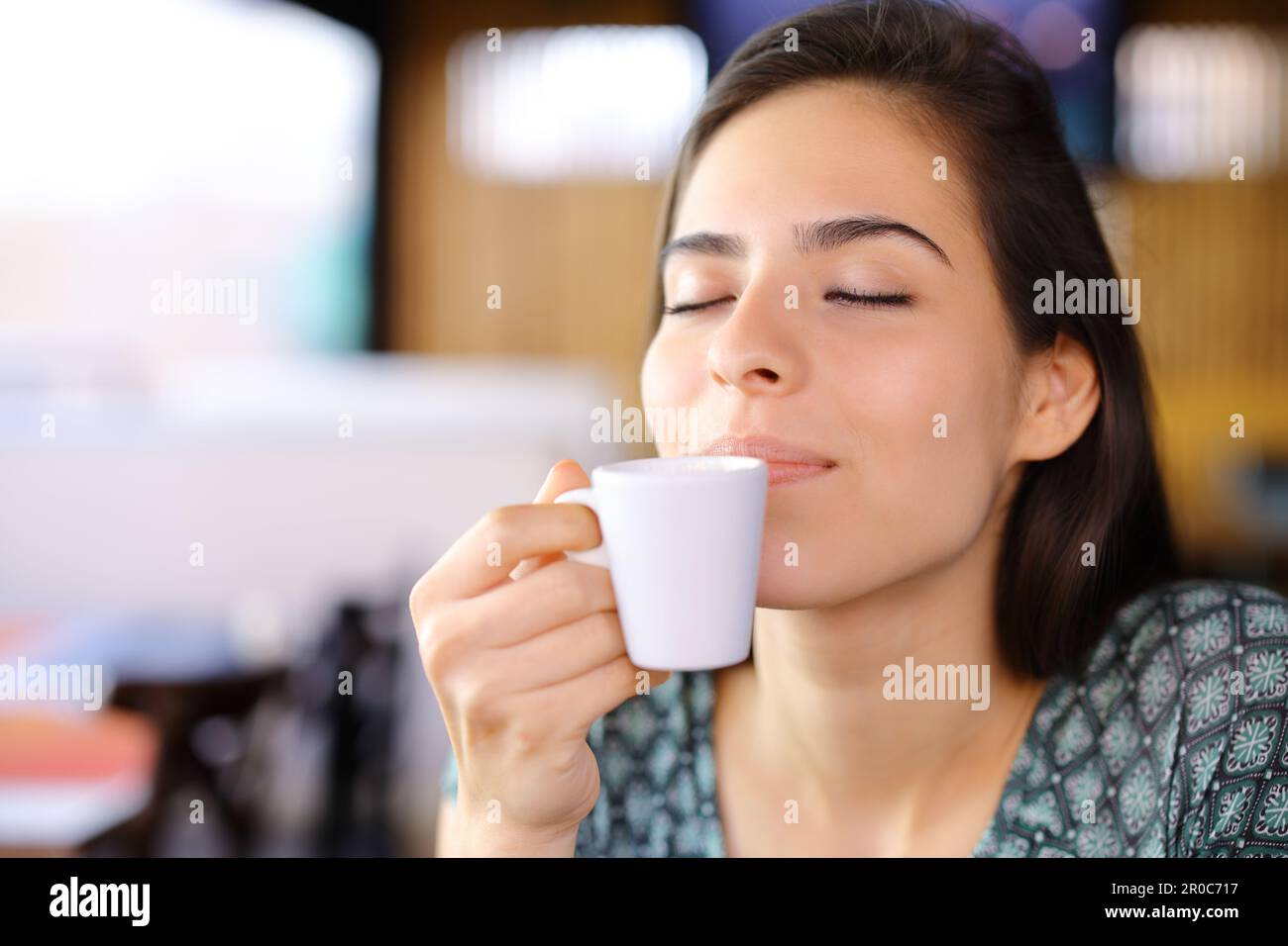 Relaxed woman smelling coffee cup in a restaurant Stock Photo