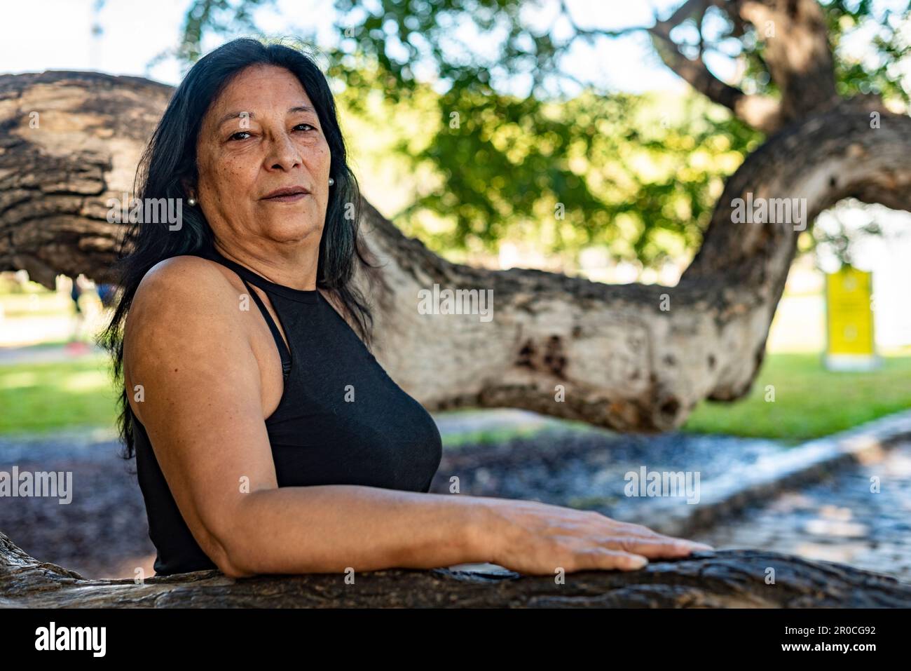 A woman posing looking at the camera in a public park Stock Photo - Alamy
