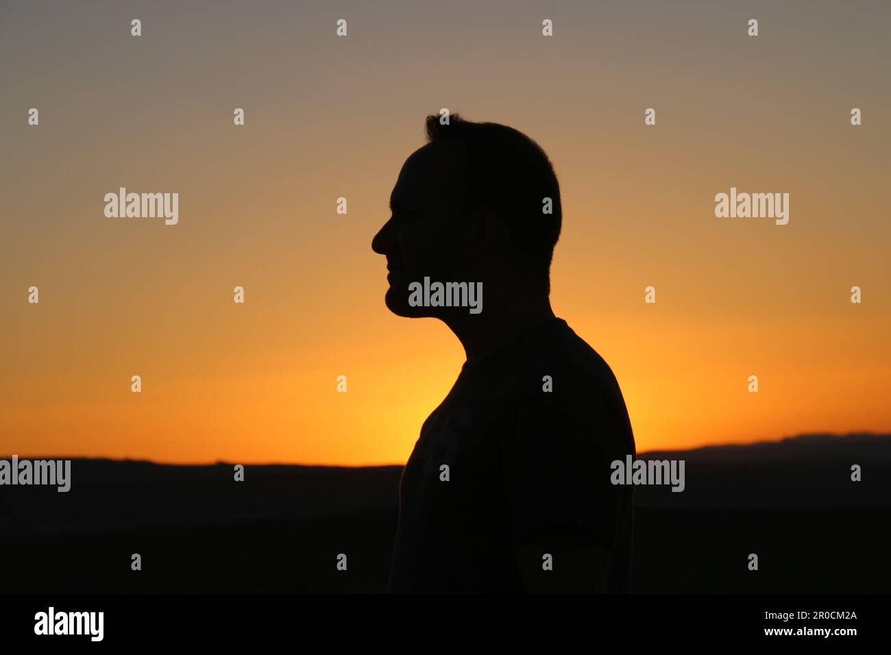 Silhouette of a profile of a man at sunset Stock Photo