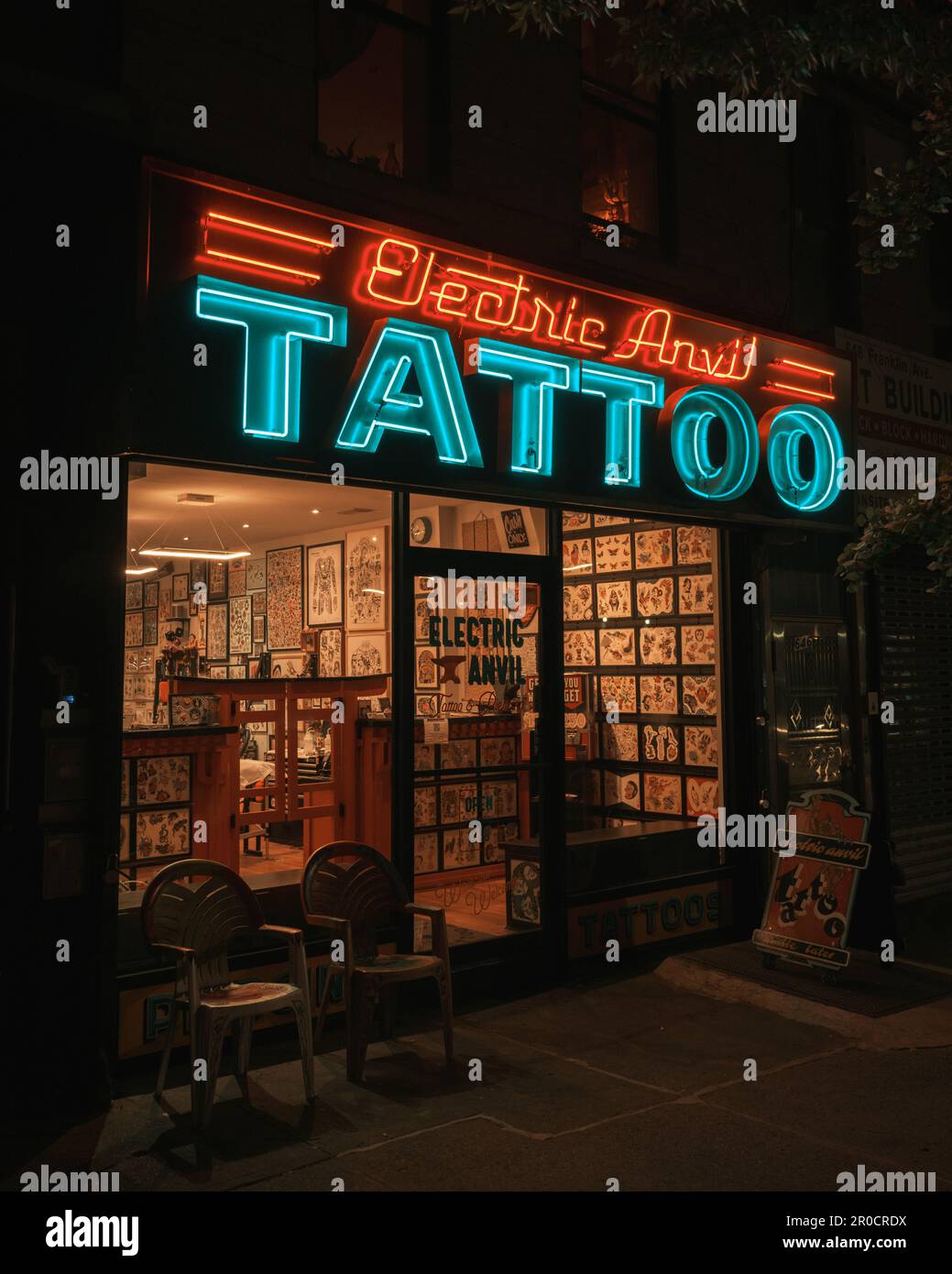Electric Anvil Tattoo & Piercing neon sign at night in Crown Heights