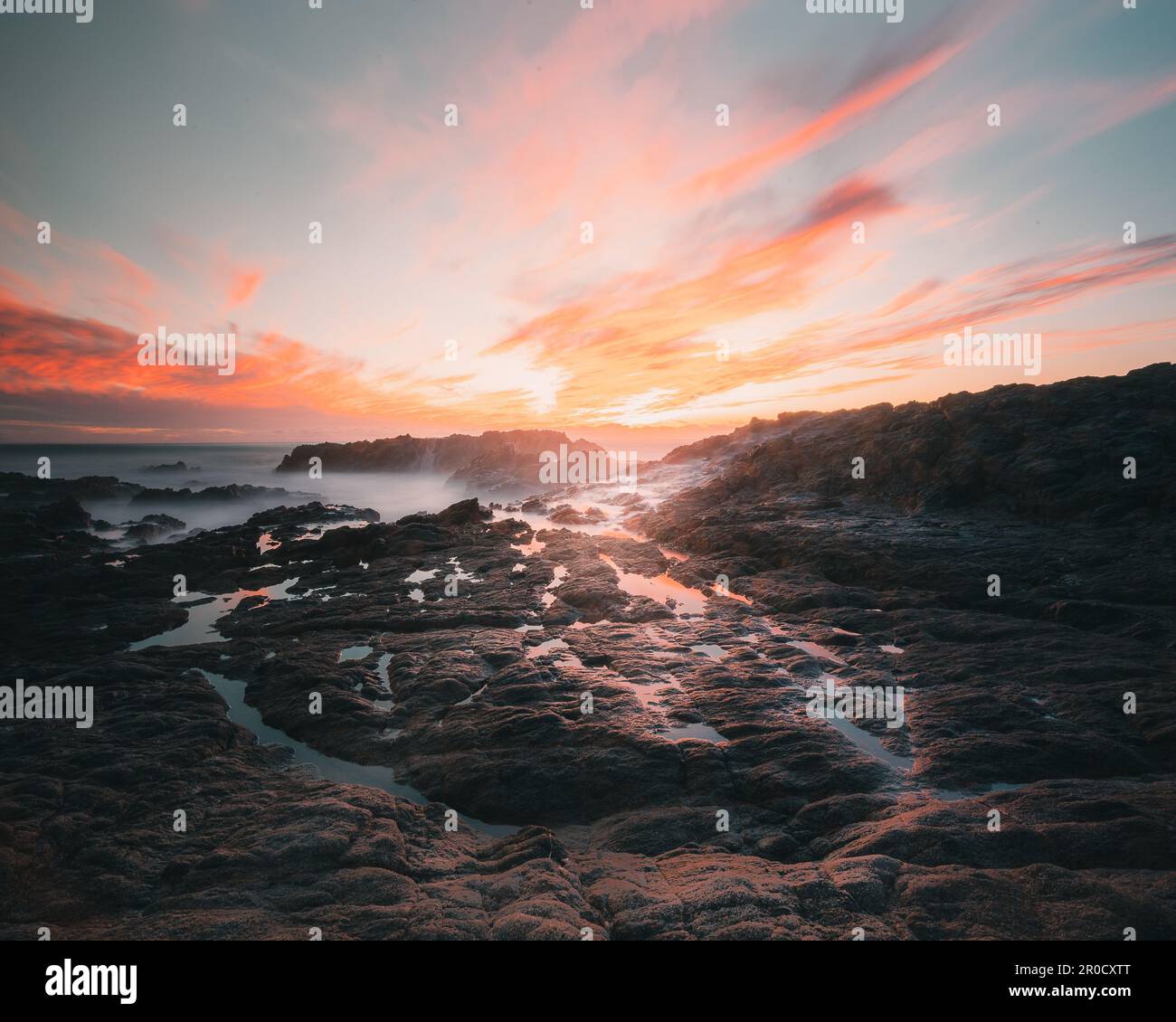 An aerial view of sea waves breaking rocky beach during sunset Stock ...