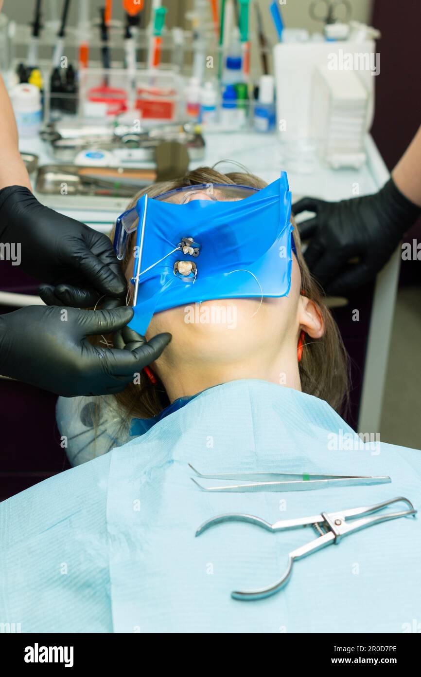 Doctor and help assistant isolate patient's teeth with rubber pad