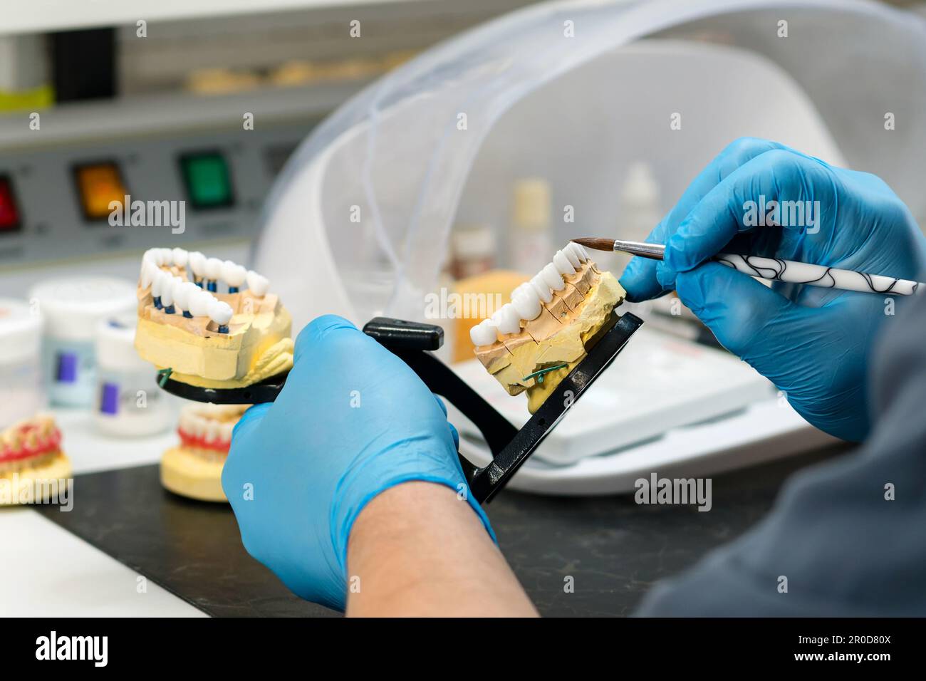 Dental prosthesis work. Denture work. Teeth painting. Dental technician working with tooth