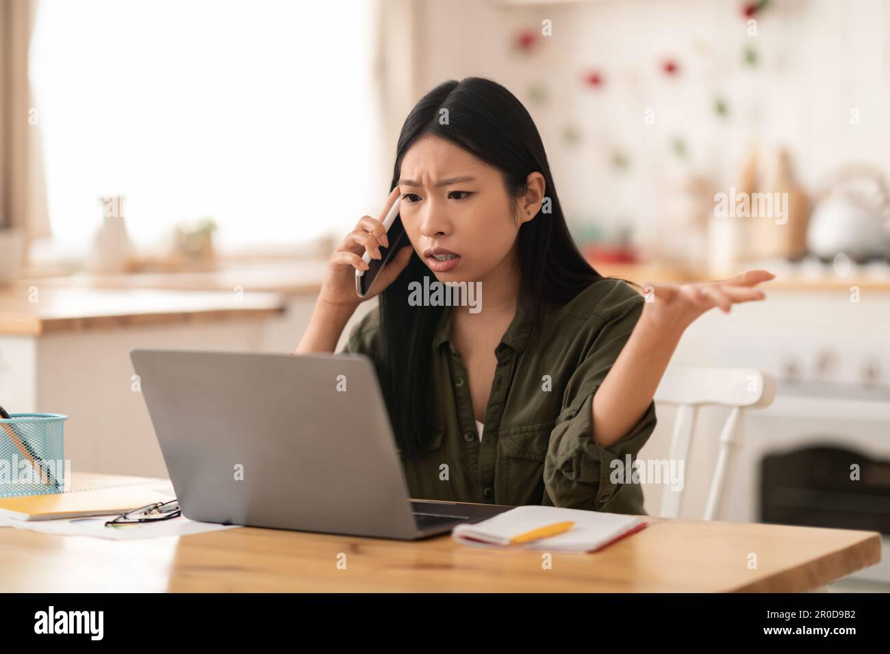 Angry asian businesswoman fighting with assistant on phone Stock Photo