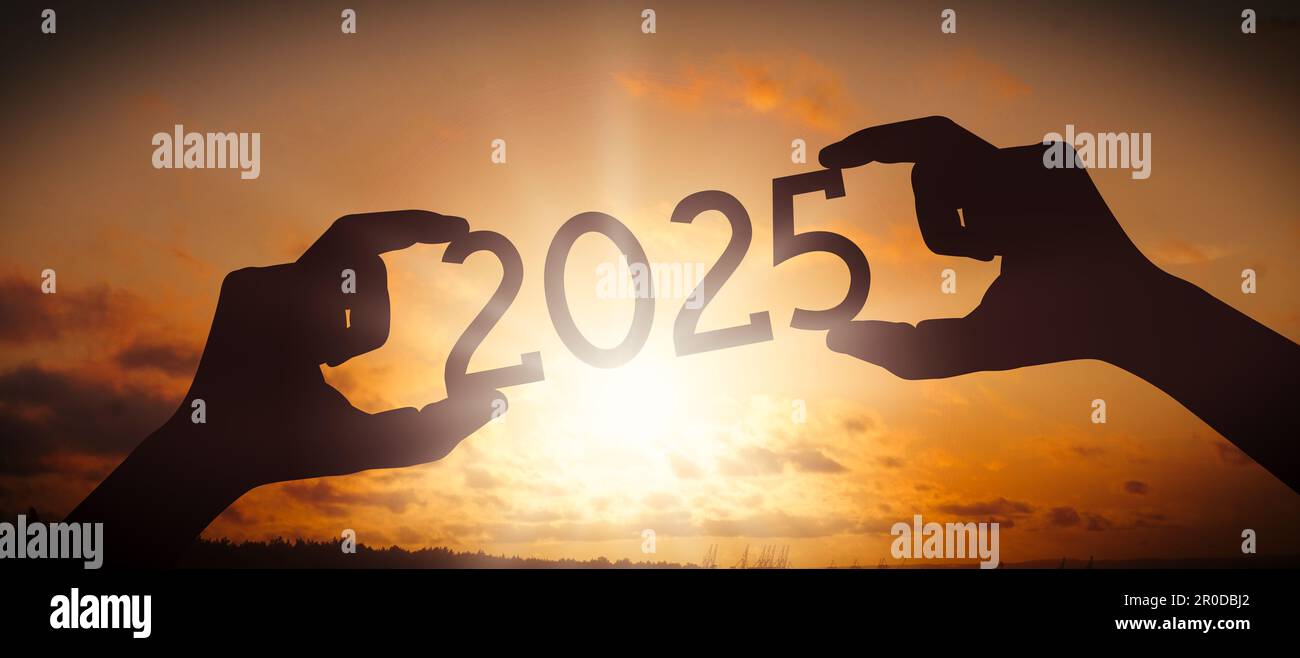 2025 - human hands holding black silhouette year number Stock Photo - Alamy