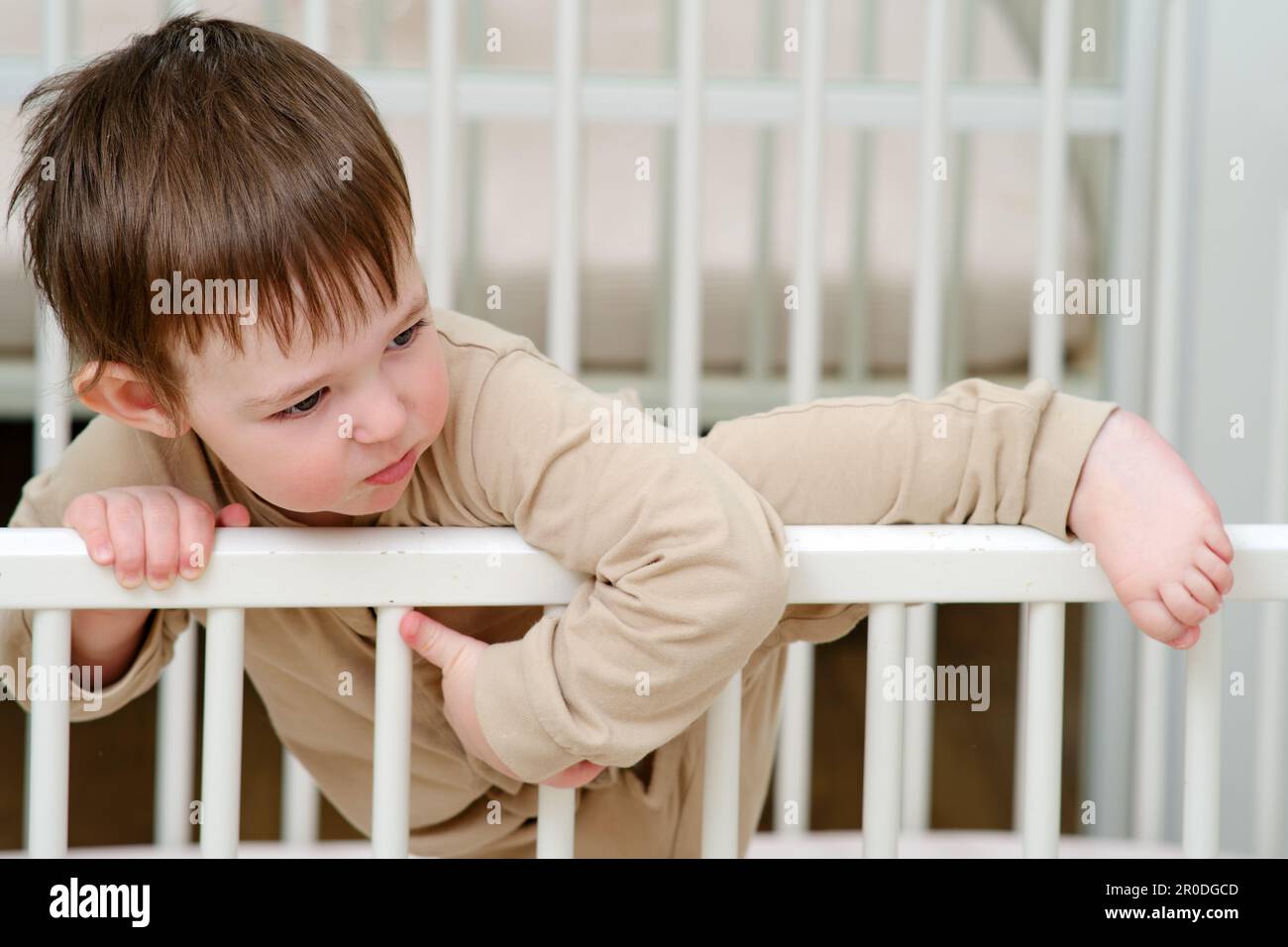 Baby escapes from the crib by climbing over the bars. The child climbs