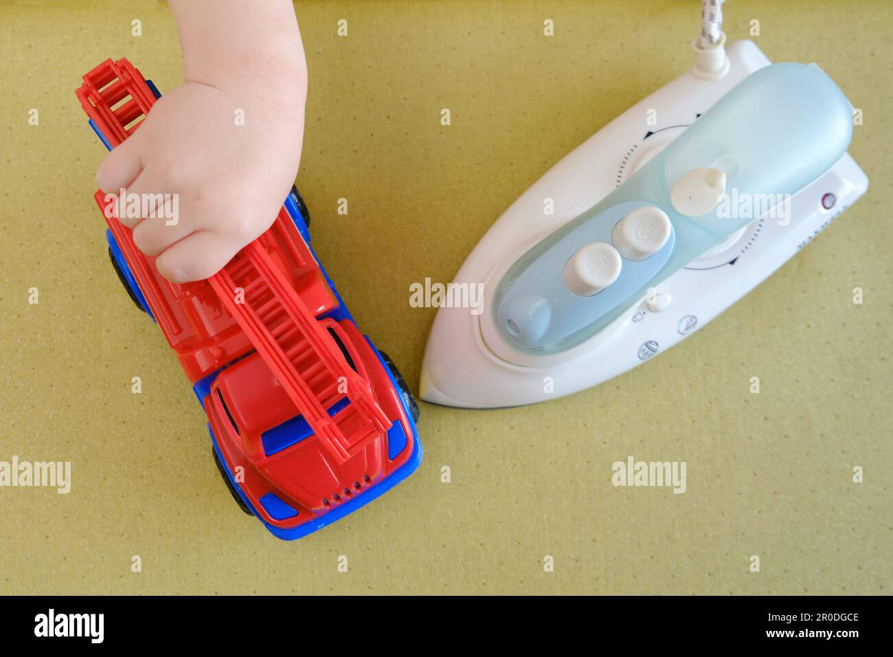 Baby's playtime with a hot iron in the living room can be dangerous if