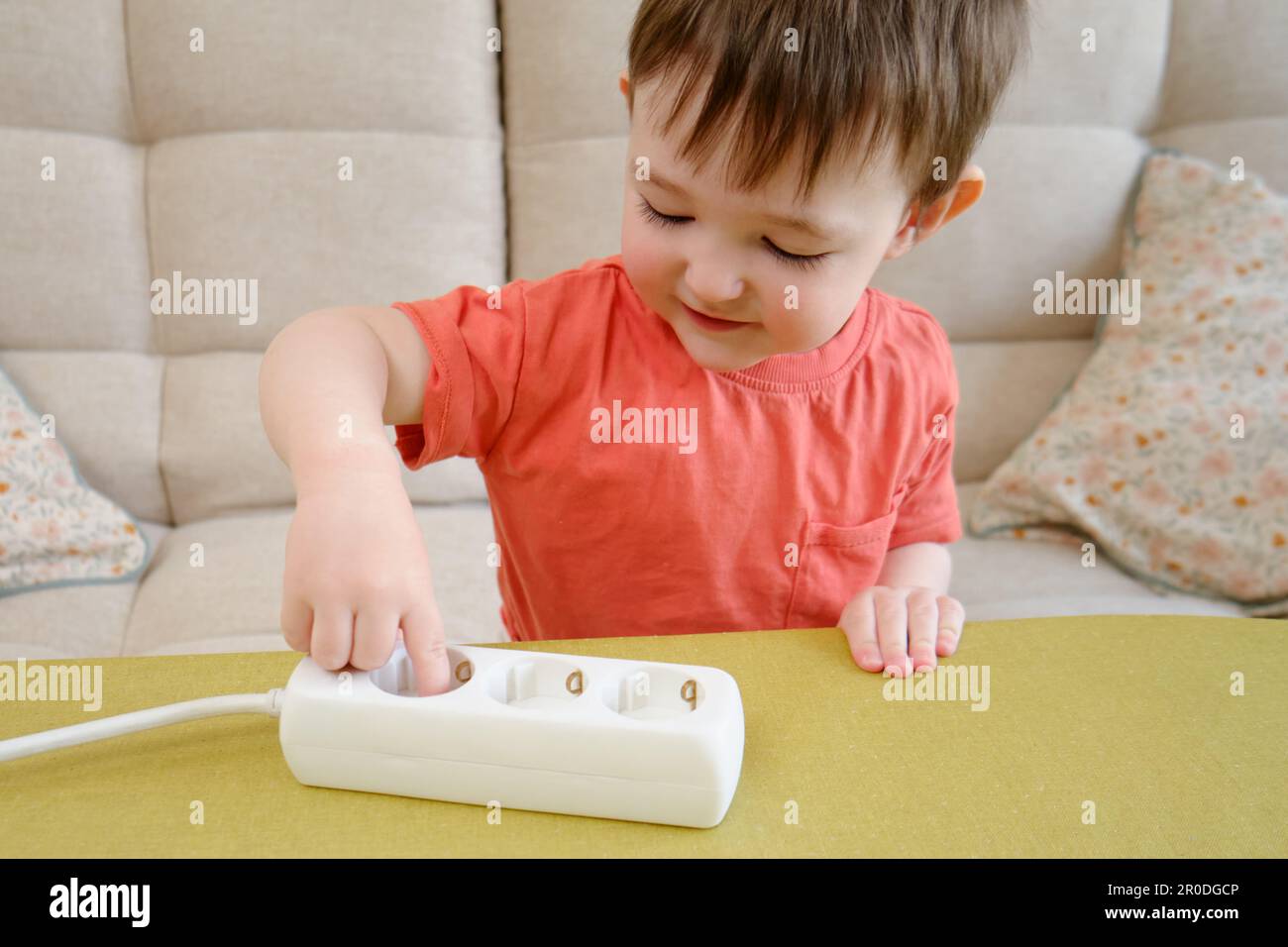 Little baby playing with electrical cords at home is a dangerous activity that could result in