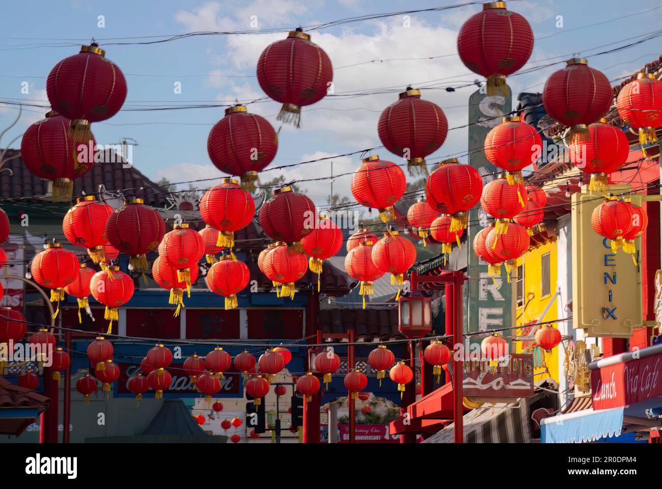 A bustling city street decorated with red traditional Chinese lanterns ...