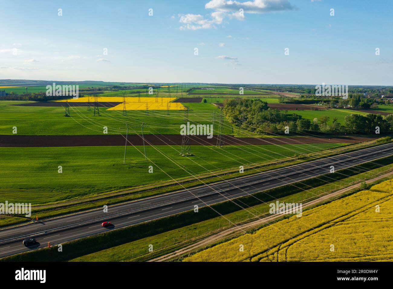 Aerial view of electricity pylon with power lines over agricultural ...