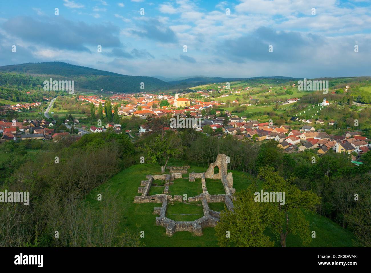 Aerial panoramic view about Schlossberg church ruins surrounded by forest. Mecseknádasd at the background. Stock Photo