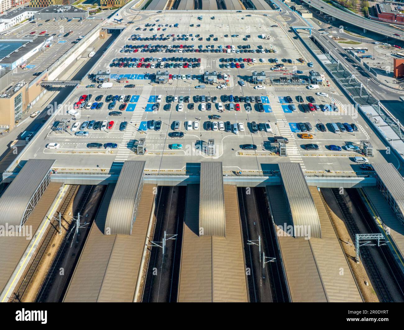 Big parking lot on the roof of the Main railroad station in Krakow, Poland. Roofed platforms, electric traction, cars and lifts down to platforms and Stock Photo