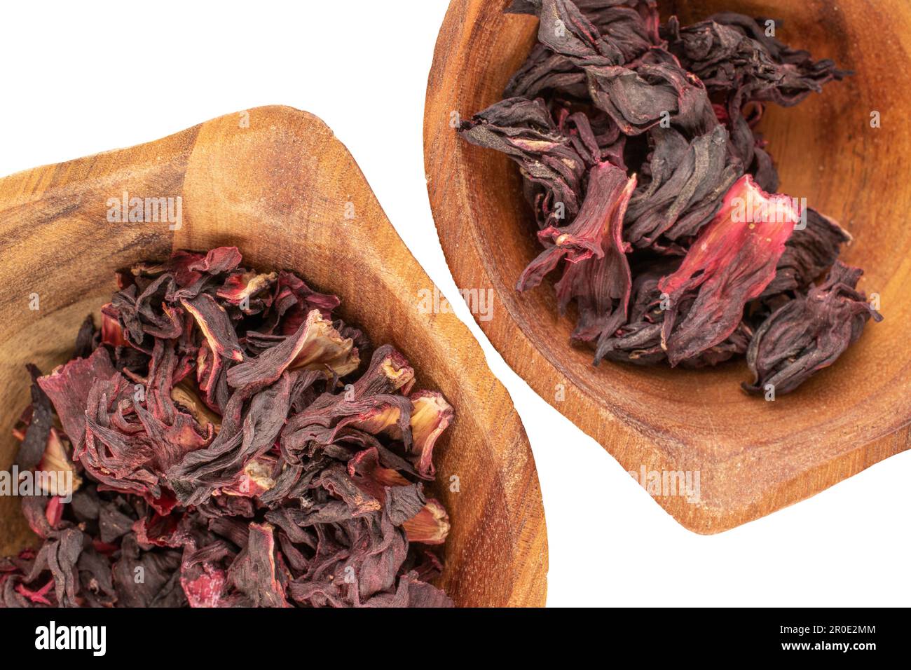 Dry fragrant karkade tea in two wooden cups on a white background ...