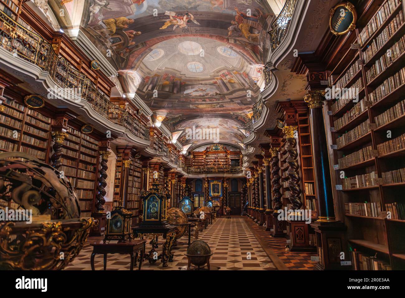 Wide-angle view of the Baroque library of the Clementinum in Prague (ca. 1556), full of books, frescos and geographical and astronomical globes. Stock Photo