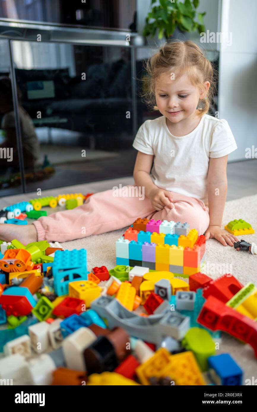 Little girl play with constructor toy on floor in home, educational ...