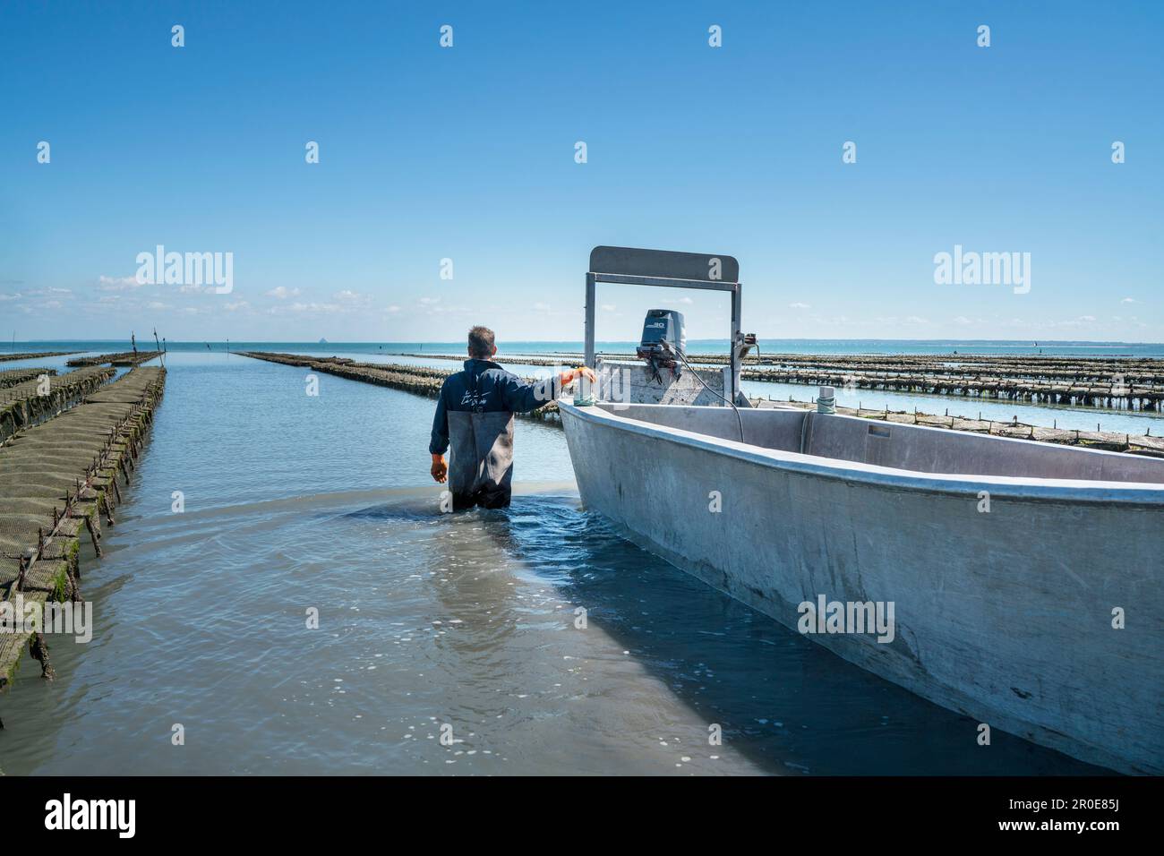 An oyster farmer with boat, Cancale, Brittany, France Stock Photo