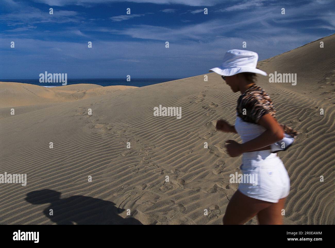 Woman jogging along the sanddunes at Playa del Ingles, Gran Canaria, Canary Islands, Spain Stock Photo