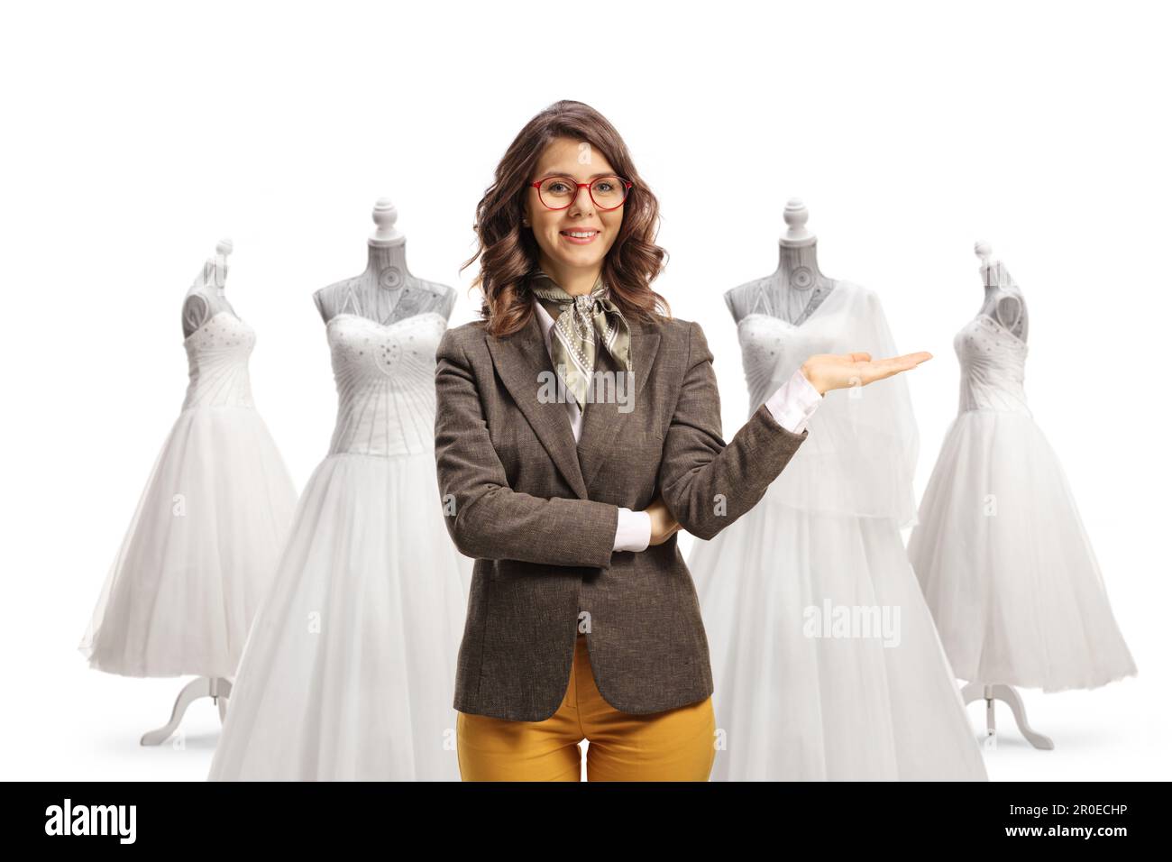 Young female standing in front of bridal gowns and pointing isolated on hite background Stock Photo