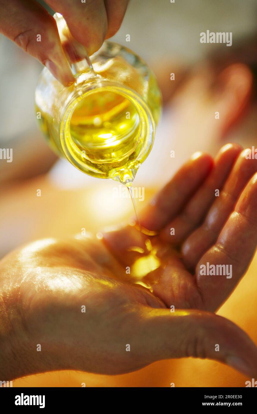 Pouring oil in hands Stock Photo