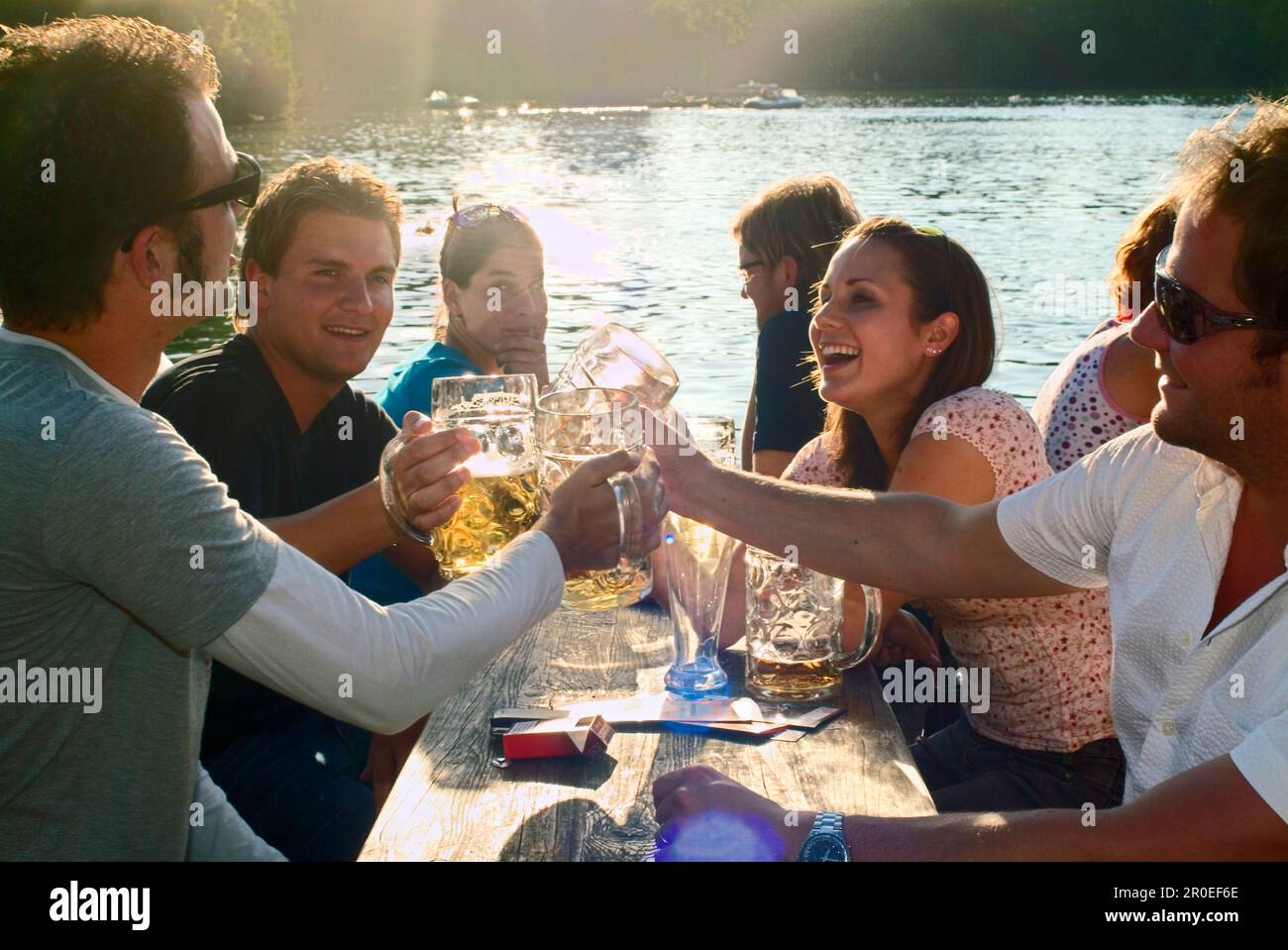 Young people sitting and toasting in beer garden, Seehaus, English Garden, Munich Stock Photo