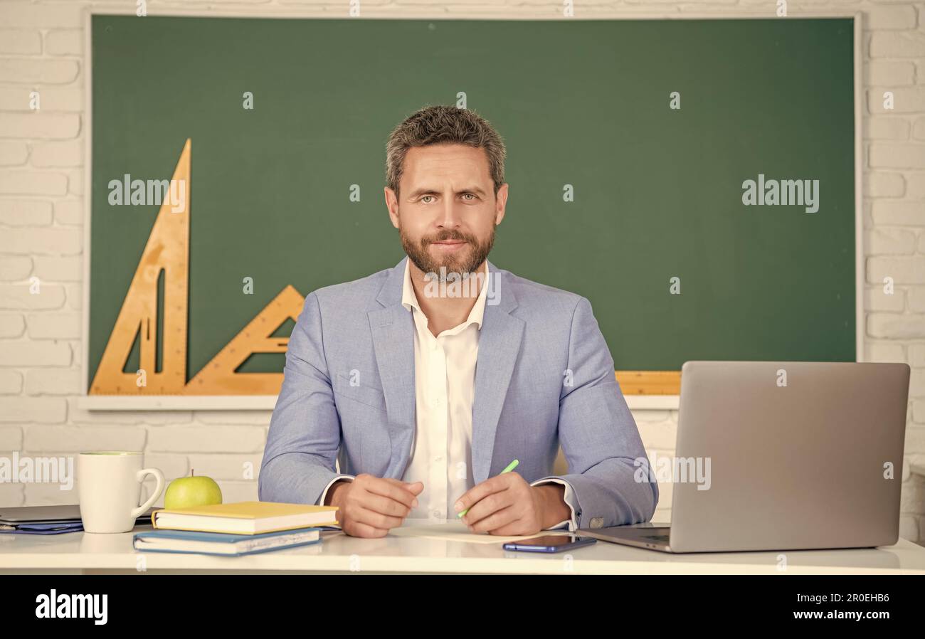 cheerful school teacher in classroom with laptop at blackboard Stock ...
