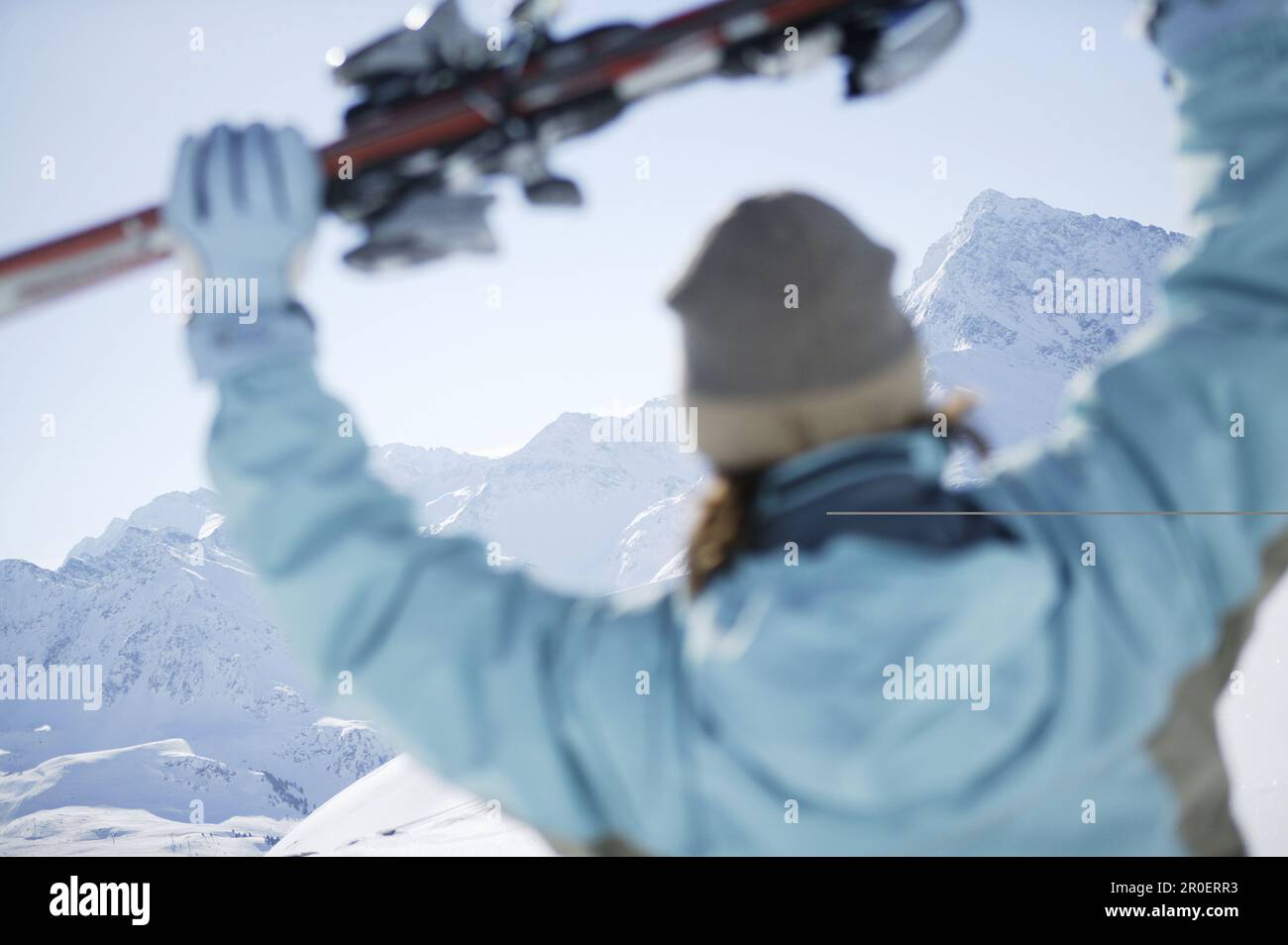 Woman holding skis, Kuehtai, Skifahrerin, Hohe Mut und Gaiskogel im Hintergrund, Kuehtai, Tyrol, Austria Stock Photo