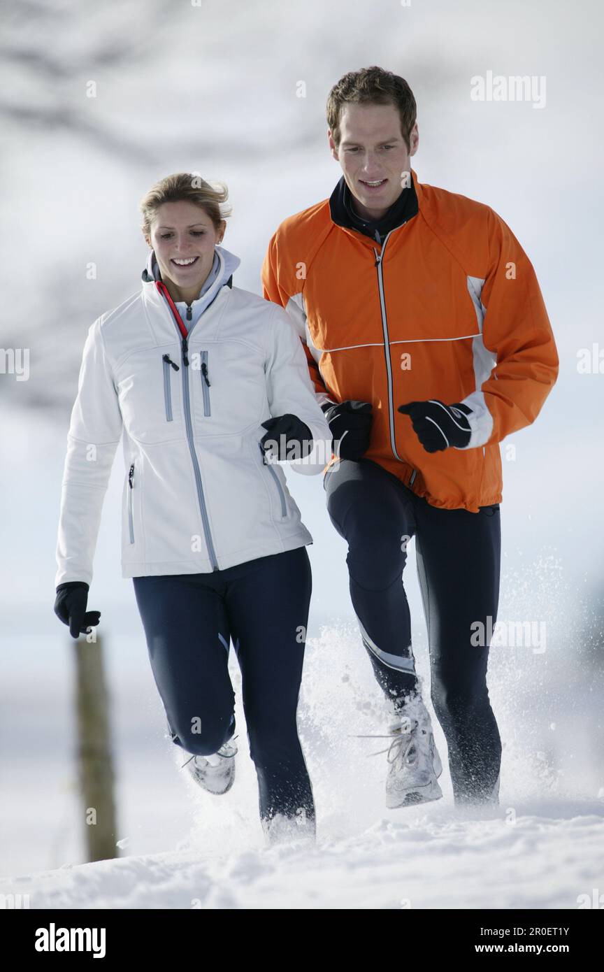 Young couple running on snow Stock Photo