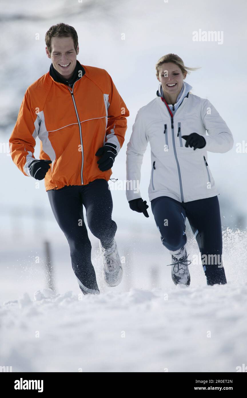 Young couple running on snow Stock Photo