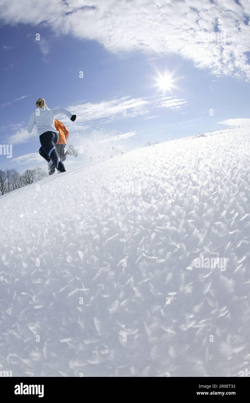 Young couple running through deep snow Stock Photo