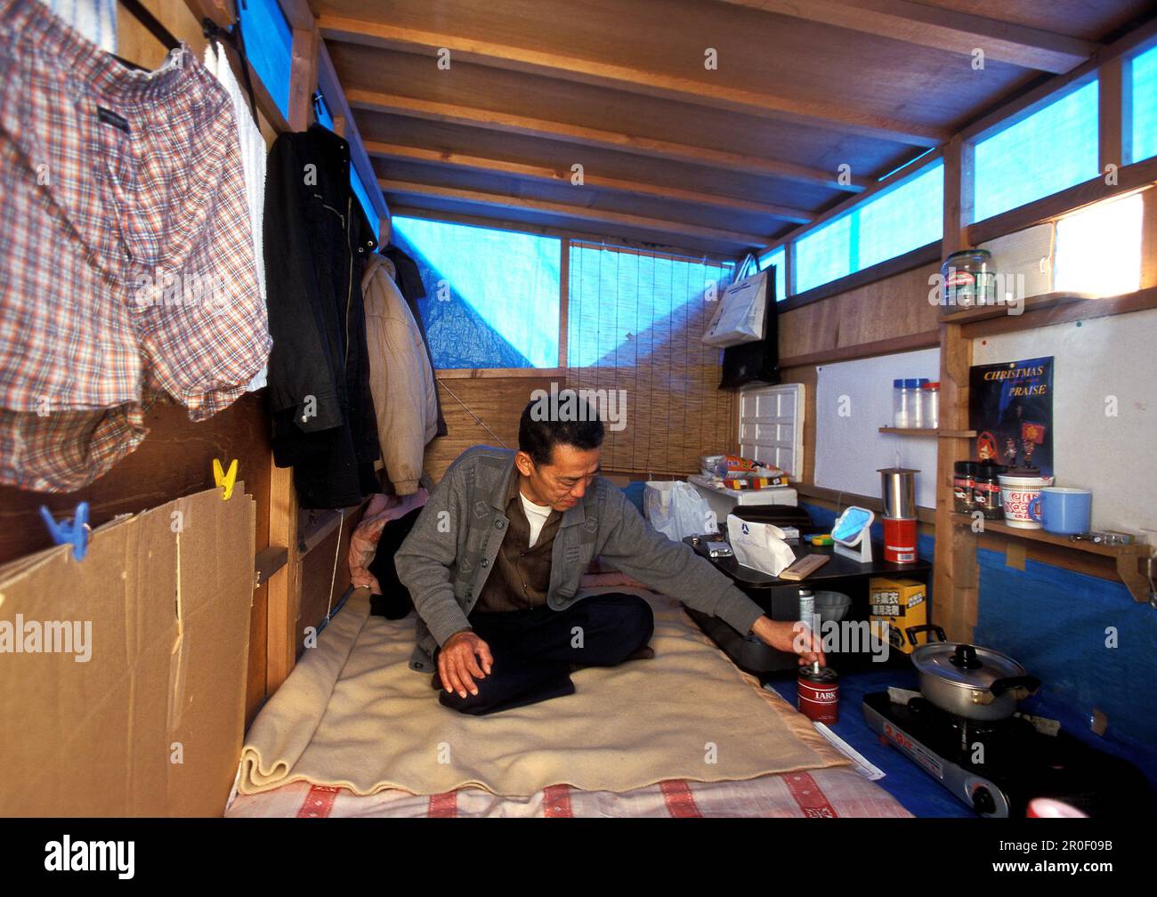 Homeless, living boxes in Tokyo, Japan, Man in his self made plywood hut on the Sumida River banks Obdachlose, notduerftige Schutzbauten, Pappkarton-A Stock Photo