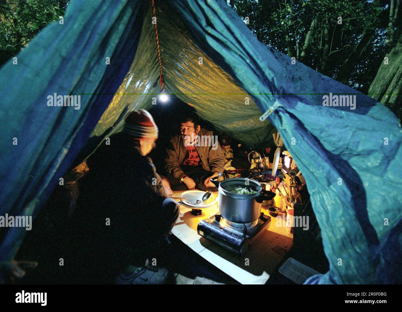 Homeless, living boxes in Tokyo, Japan, Homeless community in Ueno Park couple in basic plastic tent cooking hot dinner Obdachlose, notduerftige Schut Stock Photo