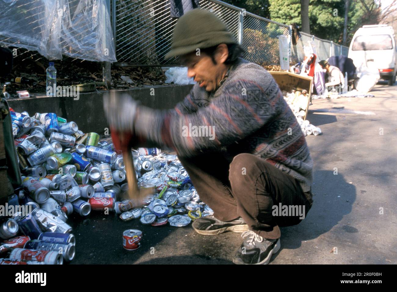 Homeless, Ueno Park, Tokyo, Japan, Temporary low paid jobs for homeless, collecting aluminium cans for recycling, crushing cans Obdachlose, notduerfti Stock Photo